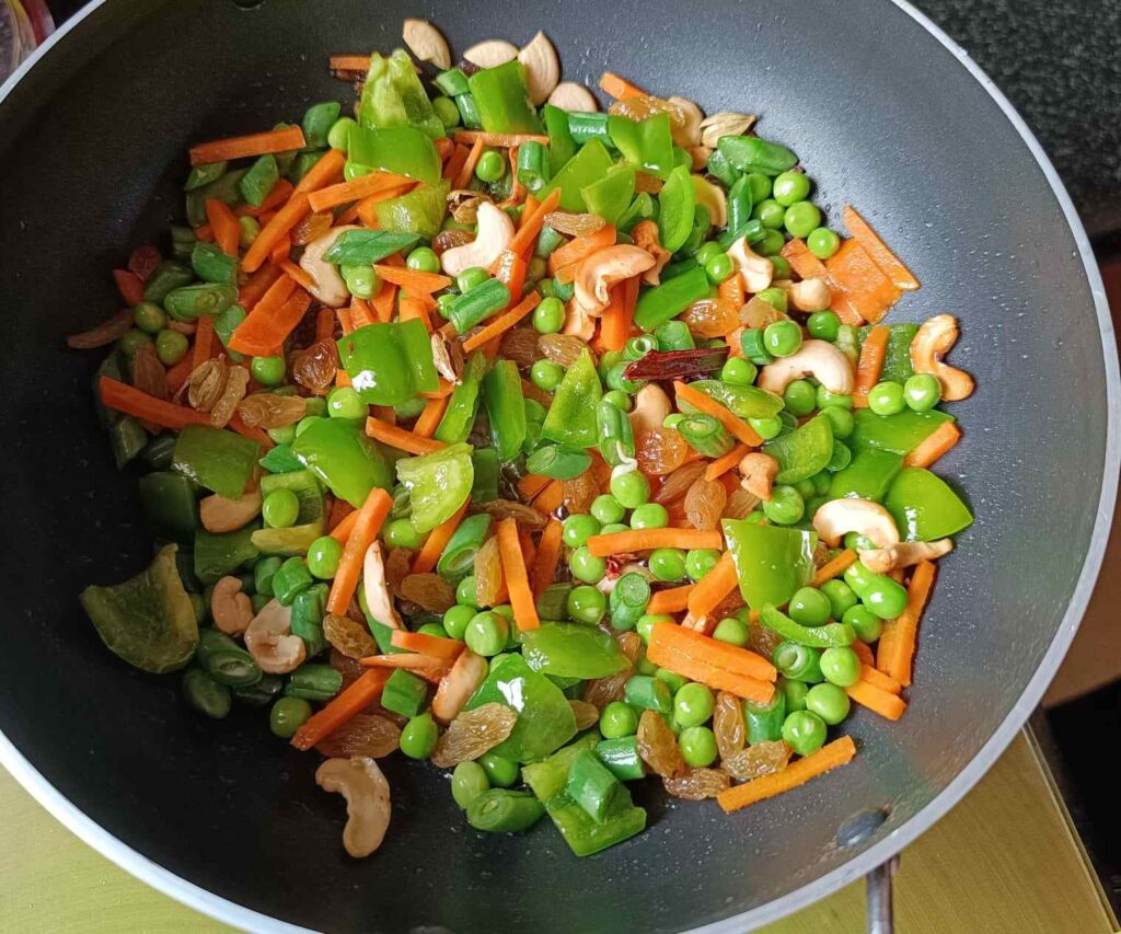 Frying all the vegetables with cashews and spices to make veg fried rice