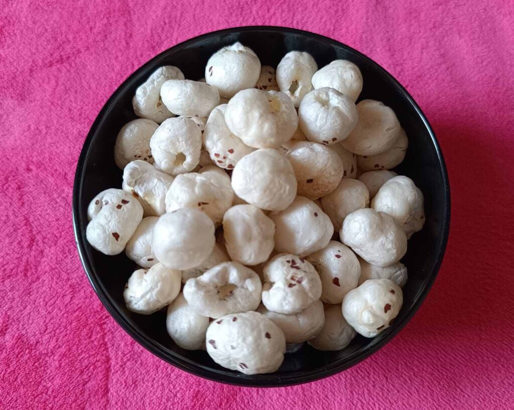 Easy weight loss meal makhanas are kept in a black bowl upon a pink towel