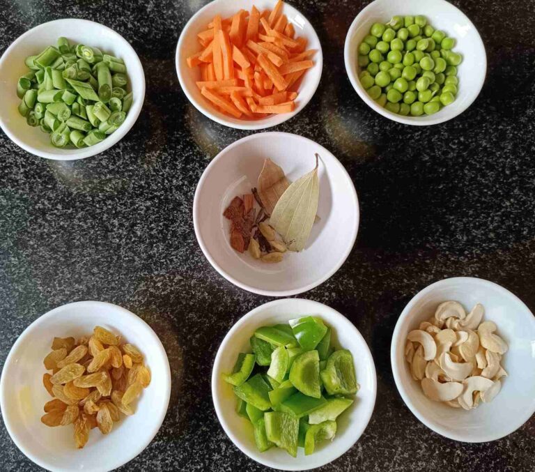 All the ingredients of veg fried rice. Beans, carrot, green peas, raisins, chopped capsicum, cashews