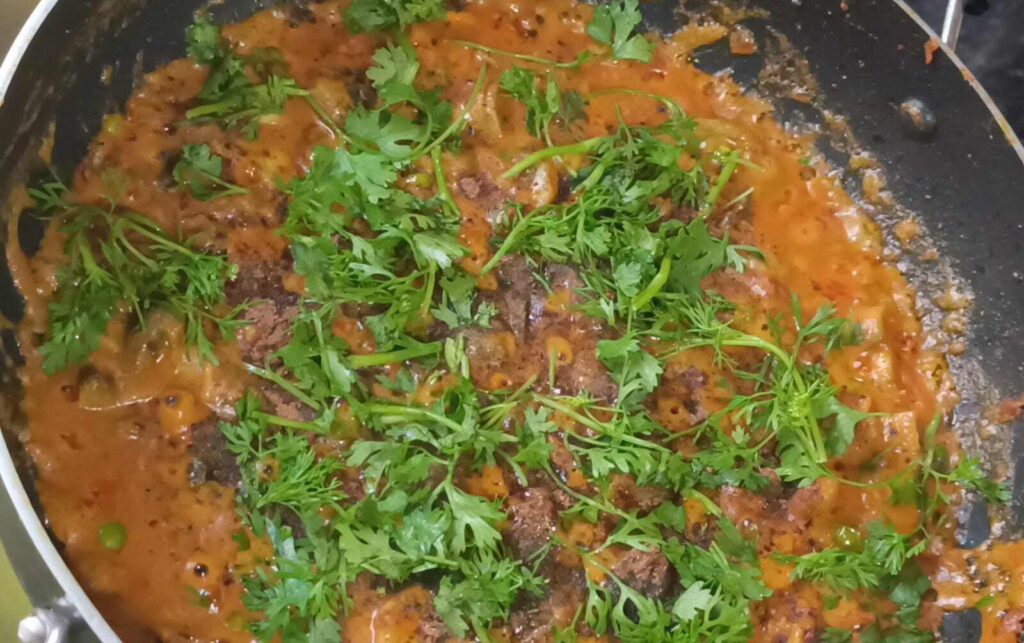 Coriander leaves, green peas, mushrooms and all the spices are mixed to get ready matar mushroom ki sabji