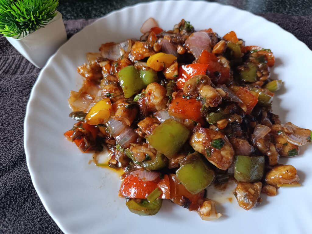 a plate of chilli mushroom recipe on a table