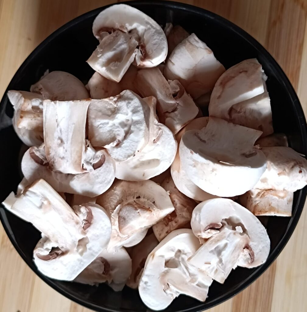 a bowl of sliced mushrooms for chilli mushroom recipe