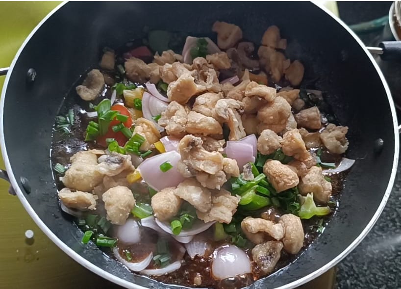 Bellpeppers,onions, spring onions and fried mushrooms added in wok with sauce for chilli mushroom recipe