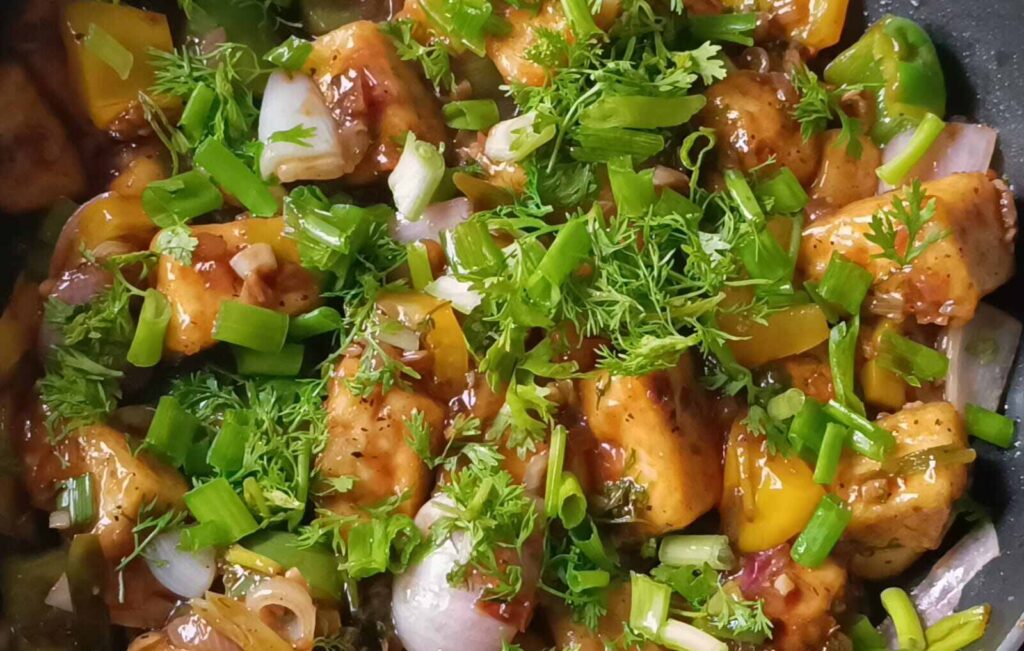 garnish with green spring onions and chopped coriander leaves for veg chilli paneer