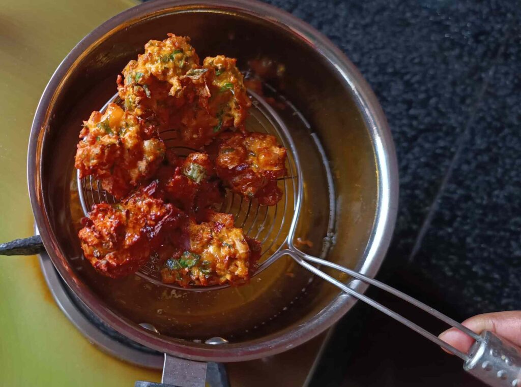 Frying sweet corn pakoda in hot oil